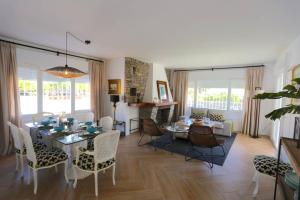 una sala da pranzo e un soggiorno con tavolo e sedie. di VILLA LUNA Beach Premium 9PAX a Torre de Benagalbón