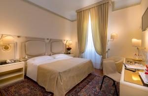 a bedroom with a large white bed and a desk at Grand Hotel Tettuccio in Montecatini Terme