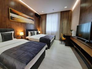 a hotel room with two beds and a flat screen tv at Home Boutique Hotel in Tashkent