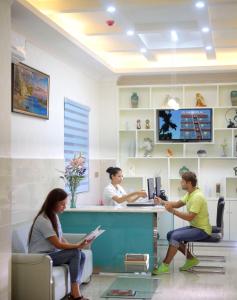 three women sitting at a counter in a pharmacy at Care Hotel Coast Collection in Sanya