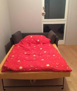 a bed with a red blanket on top of it at Stadtnähe und doch mitten in der Natur in Salzburg