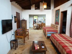 a living room with two beds and a tv at Casas Capulana in Icaraí