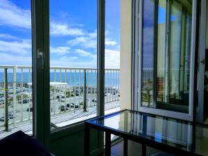 a balcony with a table and a view of the ocean at Les Aigues Marines - belle vue mer et port in Palavas-les-Flots