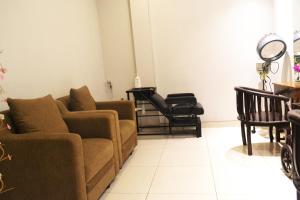 a living room with a couch and chairs at Grand Cakra Hotel Malang in Malang