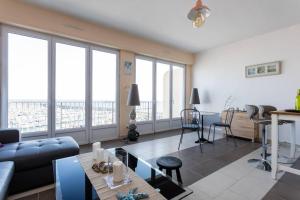 a living room with a couch and a table at Les Aigues Marines - belle vue mer et port in Palavas-les-Flots