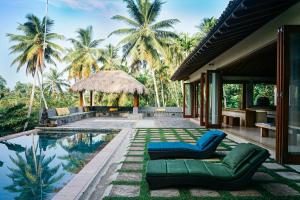 a villa with a swimming pool and palm trees at Kumara Luxury Villa in Weligama