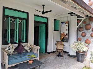 a room with a couch, chairs, and a window at Parawa House in Galle