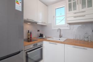 a kitchen with white cabinets and a sink at The view 3 in Santa Marina