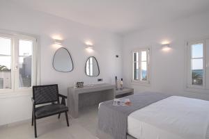 una camera con letto, sedia e specchio di The view 3 a Santa Marina
