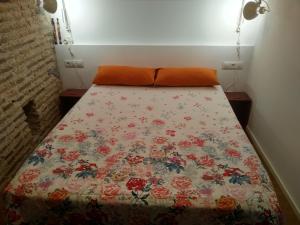 バレンシアにあるLoft en centro históricoのベッドルームに花柄の掛け布団付きのベッド1台が備わります。