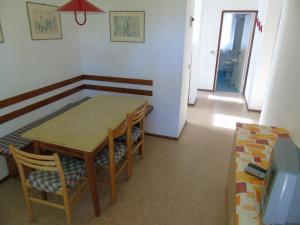 una sala da pranzo con tavolo e sedie di Casa Mecchia a Lignano Sabbiadoro