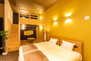 1 dormitorio con cama y pared amarilla en Sakura Stay Keikyukamata, en Tokio