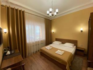 una camera da letto con un letto con due asciugamani sopra di Сонячна Соната a Polyana