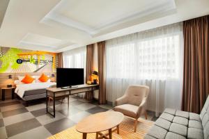 贝克西ibis Styles Bekasi Jatibening的配有床和电视的酒店房间