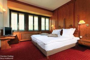 A bed or beds in a room at Hotel - Restaurant Le Cerf & Spa