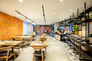 a restaurant with tables and chairs and a brick wall at ibis Styles Bekasi Jatibening in Bekasi