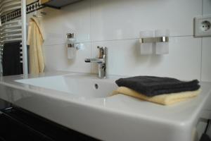 a white bathroom sink with a black towel on it at Villa Harmonie W1 in Göhren-Lebbin +58 photos