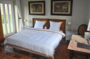 Un dormitorio con una gran cama blanca y una ventana en B&B Kasteelhoeve de Tornaco, en Borgloon