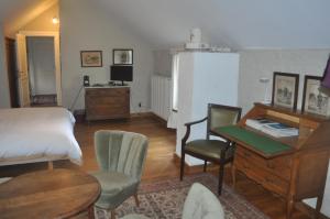 a bedroom with a bed and a desk with chairs at B&B Kasteelhoeve de Tornaco in Borgloon