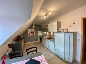 eine Küche mit einem weißen Kühlschrank und einem Tisch in der Unterkunft Ferienwohnungen Conny in Rudolstadt