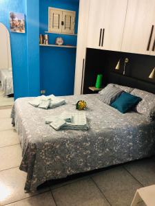 una camera blu con un letto con un tavolo con fiori di Sea View 2 Bedroom Vacation Apartment a Giardini Naxos