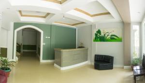 una habitación con una pared verde y una silla negra en Sandscape Hotel en Bantayan Island