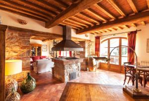 a living room with a stone fireplace and a table at Agriturismo & Cantina Tenuta Casteani in Ribolla