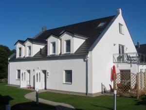 a white house with a black roof at Villa Harmonie W1 in Göhren-Lebbin