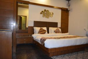 a bedroom with a large bed with a wooden headboard at JJK @ STAY HOME in Dehradun