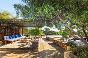 a patio with couches and tables and a pool at Villa Can Toni Mateu in Sant Francesc Xavier