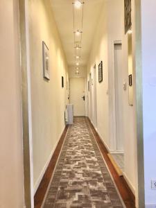 pasillo largo con suelo de baldosa y paredes blancas en Bordorent Apartment, en Burdeos