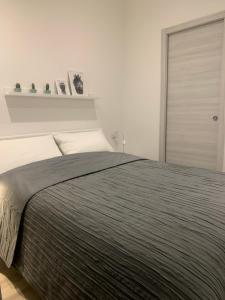 sypialnia z dużym łóżkiem i szarym kocem w obiekcie CATANIA CENTRAL DELUXE HOUSE w Katanii