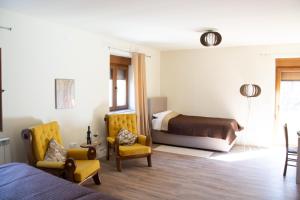 a bedroom with a bed and two chairs and a bed at Zvjezdana dolina Garni hotel in Andrijevica