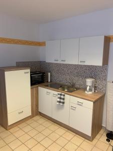 a kitchen with white cabinets and a counter top at Ferienwohnung Buddha in Langelsheim