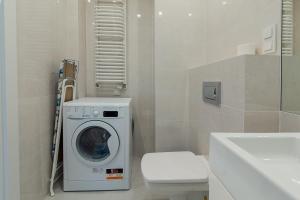ein Badezimmer mit einer Waschmaschine und einem Waschbecken in der Unterkunft Warsaw To Be - Blue Apartment in Warschau