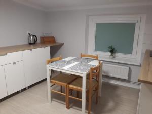 a kitchen with a table and chairs and a window at Apartament Mariacka Two in Bydgoszcz