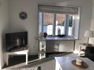 a living room with a television and a large window at Reethüs am Klintumer Moor in Leck