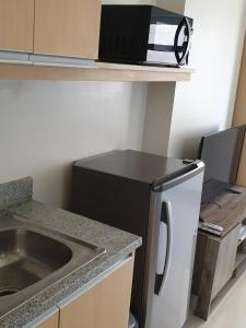 a kitchen with a washing machine and a sink at Modern & Comfy Studio - 10 Mins to SM Seaside in Cebu City