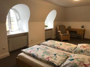 a bedroom with a bed and a desk and two windows at Reethüs am Klintumer Moor in Leck