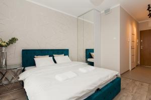 a bedroom with a large bed with a blue headboard at Warsaw To Be - Silver Apartment in Warsaw