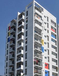 un edificio alto de color blanco con ventanas y balcones coloridos en NAAS Serviced Apartments, en Dhaka