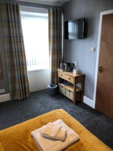 una camera d'albergo con un asciugamano su un letto e una finestra di Sinclair Bay Apartments a Keiss
