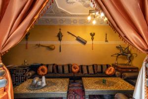 een woonkamer met een bank en 2 tafels bij RIAD MAKENE MOUCHKILL in Marrakesh