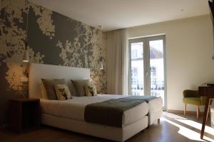 a bedroom with a bed and a large window at Barquinha Nature House in Vila Nova da Barquinha