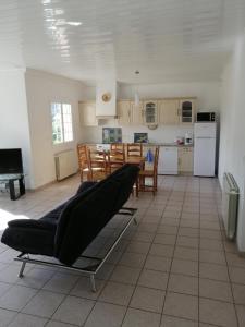 a living room with a couch and a kitchen at CHEZ MARTINE Appt climatisé 2 Chambres in Capbreton