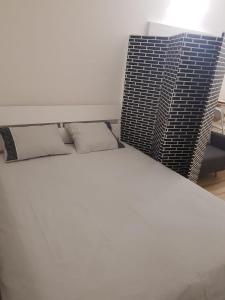 ein weißes Bett mit zwei Kissen in einem Zimmer in der Unterkunft Alojamiento para descansar en tranquilidad con todo a mano in Santa Cruz de Tenerife