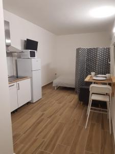 Zimmer mit einer Küche, einem Tisch und einem Bett in der Unterkunft Alojamiento para descansar en tranquilidad con todo a mano in Santa Cruz de Tenerife