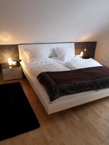 1 cama grande en un dormitorio con 2 lámparas en Ferienwohnung "Deluxe" in Korbach, en Korbach