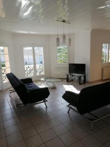 a living room with two chairs and a table at CHEZ MARTINE Appt climatisé 2 Chambres in Capbreton