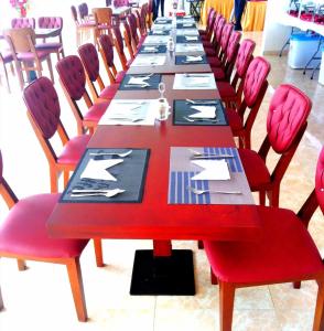 a long table in a room with red chairs at Kol Alayam Hotel in Mecca +42 photos